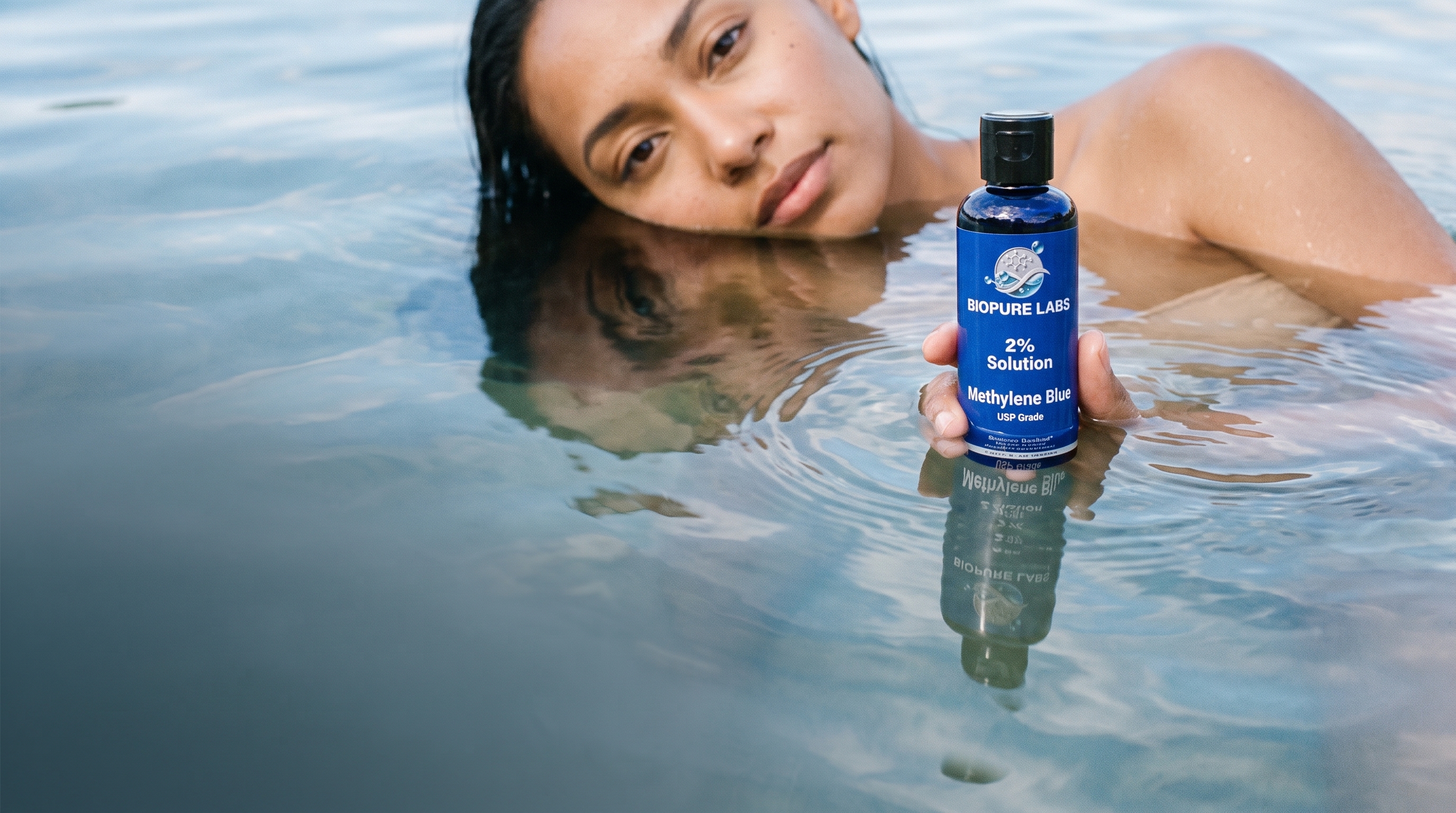 A person in water holding BioPure Labs Methylene Blue 2% Solution